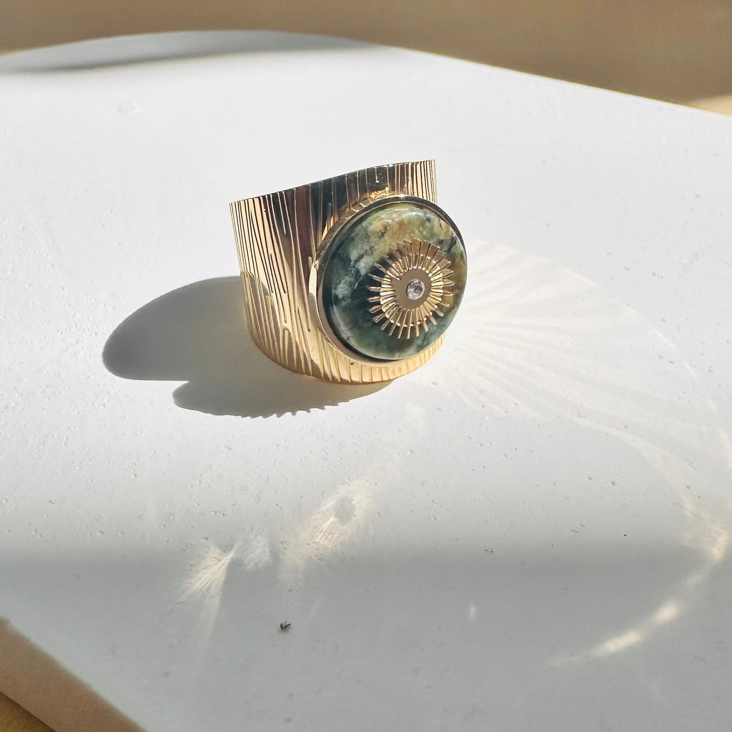 bague avec pierre verte et soleil central