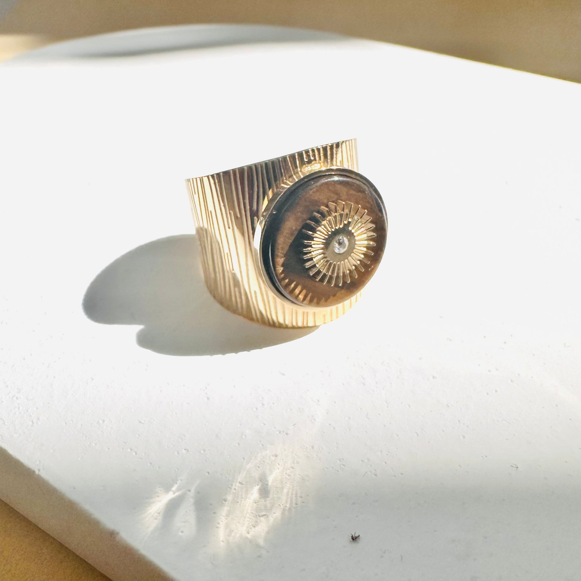 bague avec pierre marron et soleil dore